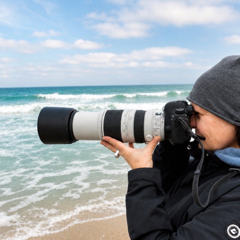 Heike Hultsch bei der Arbeit mit der Kamera am Meer.